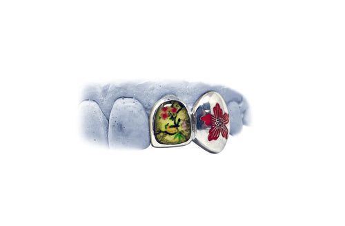 A model of an enamel multi-colored grill with two scenic floral designs with birds.