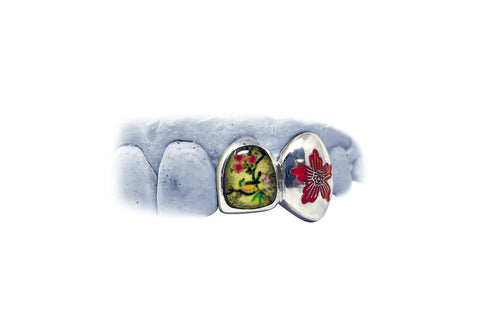 A model of an enamel multi-colored grill with two scenic floral designs with birds.