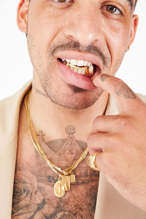 man with gold chain and diamond bridge with gold fangs