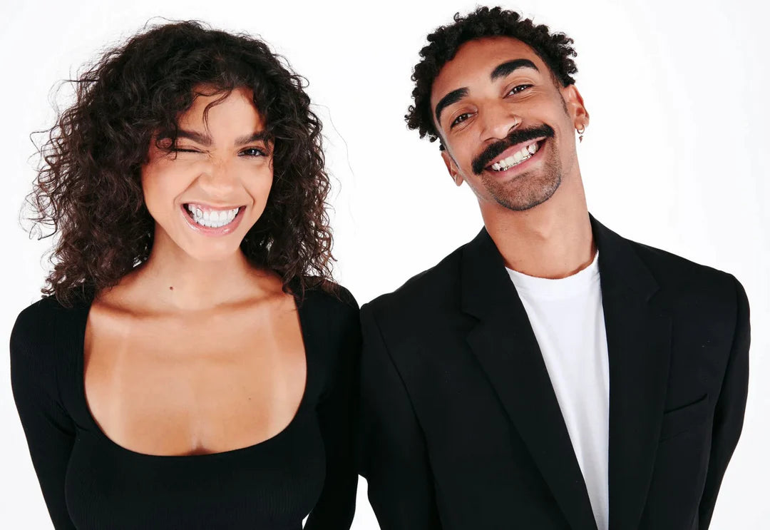 man and woman smiling with custom grillz for their teeth
